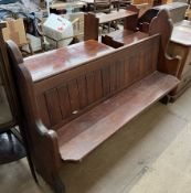 A pine pew with Ogee shaped ends and a planked back and solid seat,