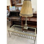 A brass coffee table of rectangular form with a glass inset top together with a brass table lamp