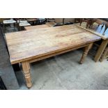 A pine refectory kitchen table with a rectangular planked top on four turned legs,