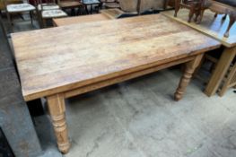A pine refectory kitchen table with a rectangular planked top on four turned legs,