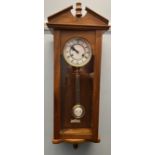A 20th century mahogany Vienna regulator type wall clock with an enamel dial and Roman numerals