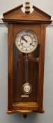 A 20th century mahogany Vienna regulator type wall clock with an enamel dial and Roman numerals