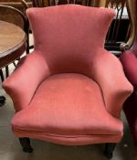 A Victorian upholstered elbow chair with an upholstered camel back,