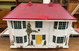 A formed metal dolls house with sliding front and dolls house furniture