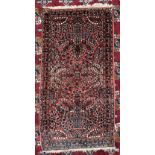 A small red ground rug with vase decorations to multiple guard stripes,