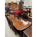 A 20th century oak extending dining table together with a matched set of five carved oak dining