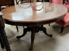 A Victorian mahogany supper table with an oval top above four turned columns and outswept feet