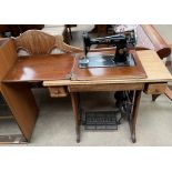 A Singer sewing machine set in a table with treadle pedal