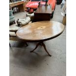 A late Victorian supper table with an oval inlaid top on a turned column and three legs