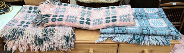 A Welsh blanket in pinks and green together with two other Welsh blankets