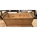 A pine dough bin of rectangular form with cut out handles and tapering sides