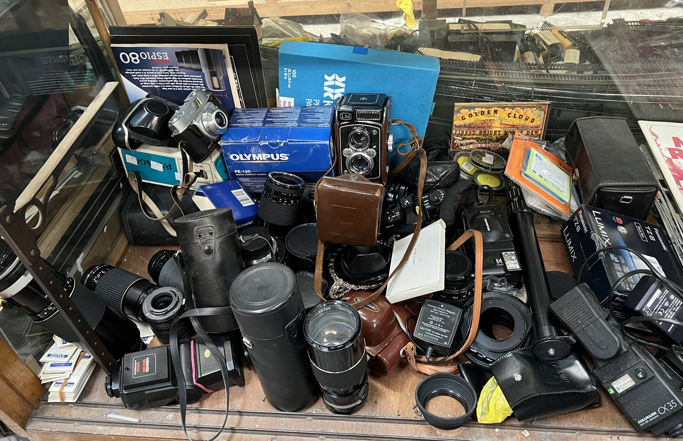 A Yashica Mat camera together with other cameras and a collection of camera lenses and accessories