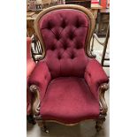 A Victorian mahogany framed gentleman's chair with a button back upholstered spoon back with pad