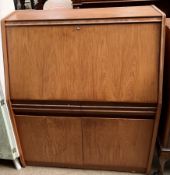 A Remploy teak bureau with a sloping fall,