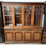 A George III style mahogany bookcase with a moulded dentil cornice above four glazed doors,