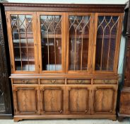 A George III style mahogany bookcase with a moulded dentil cornice above four glazed doors,