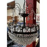 A crystal light fitting with five tiers of lustre drops and a painted chandelier