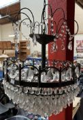 A crystal light fitting with five tiers of lustre drops and a painted chandelier