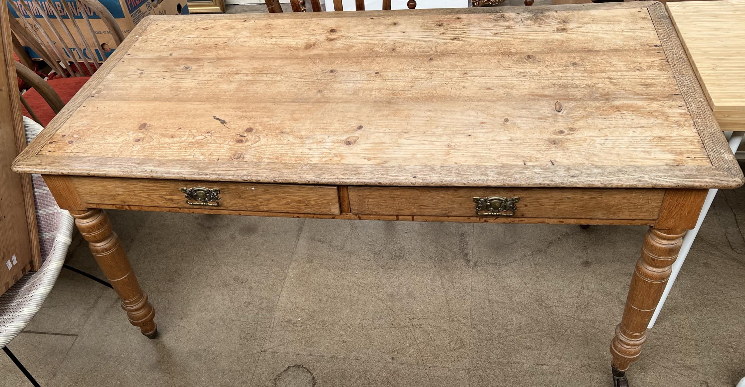 A pine and oak library type table with a rectangular top above two drawers on turned legs