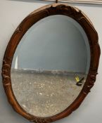 A large carved oval wall mirror