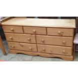 A pine chest with a rectangular top above seven drawers on bracket feet