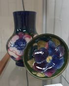 A Moorcroft pottery vase decorated with flowerheads and leaves to a blue ground,