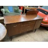 A mid 20th century teak sideboard with three central drawers and two cupboards on tapering legs