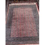 A large red ground Turkoman rug with multiple guard stripes and guls,
