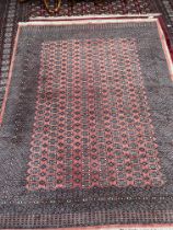 A large red ground Turkoman rug with multiple guard stripes and guls,