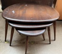 An Ercol pebble nest of tables on tapering legs