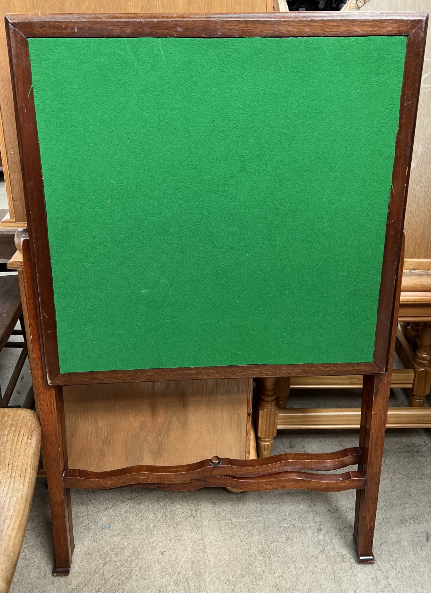 A folding card table with a square baize top