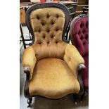 A Victorian mahogany framed lady's chair with a button back upholstered spoon back with pad arms