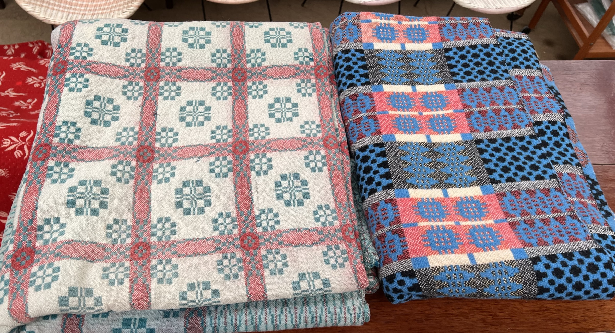 A Welsh blanket in blues and pinks together with another Welsh blanket