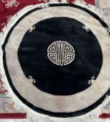 A Chinese rug with a black ground and cream border