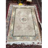 A Chinese rug with a cream ground, central flowers and a floral border,