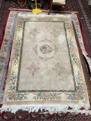 A Chinese rug with a cream ground, central flowers and a floral border,