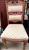 A Victorian chair with an upholstered back and seat on turned legs,