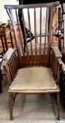 An Edwardian stick back elbow chair on turned legs