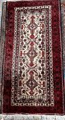 An Iranian Balouch wool rug with a cream ground and red multiple guard stripes 211 x 105cm
