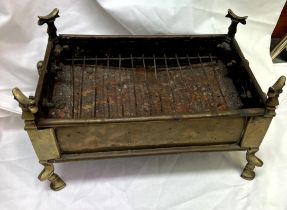 A brass charcoal stove with twin swing handles and pad feet