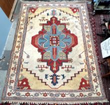 A room size rug with a cream ground and medallions, to light blue guard stripes,
