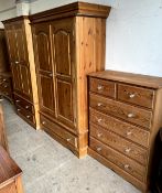 A Pine wardrobe with a pair of cupboard doors above a pair of cupboards together with another pine