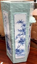 A Chinese porcelain umbrella stand of hexagonal form with lion head handles and panels of bamboo