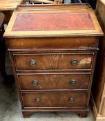 A reproduction mahogany Davenport desk with a sloping fall and three drawers