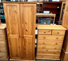A pine two door wardrobe together with a pine chest of drawers