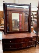 A Victorian mahogany toilet mirror with a rectangular plate and two drawers on shaped feet