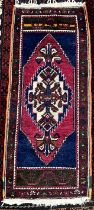 A small rug with a central medallion and blue ground with floral decorated guard stripes,