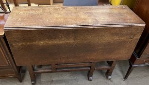 An oak gateleg dining table with a rectangular top on square legs