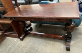 A 20th century oak refectory table with a planked rectangular top on cup and cover legs and