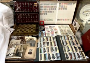 A chess set and board together with photographs, cigarette cards,